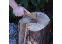 Hand using an axe to chop a wooden stump with a natural outdoor background