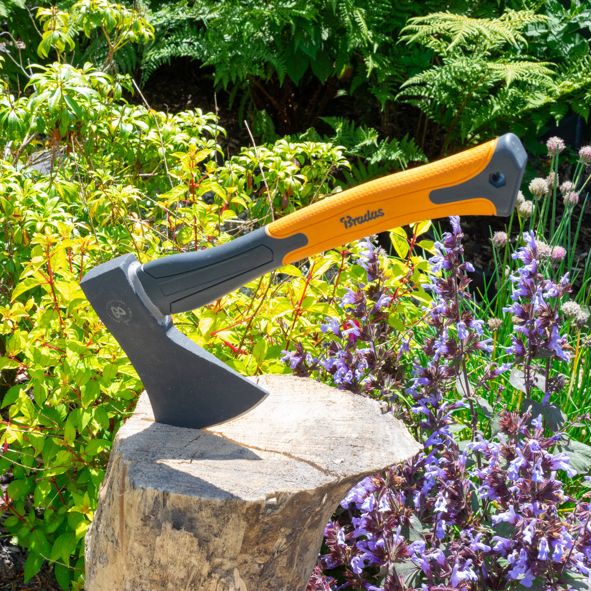 Bruder axe on a stone with greenery and flowers in the background
