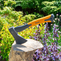 Bruder axe on a stone with greenery and flowers in the background