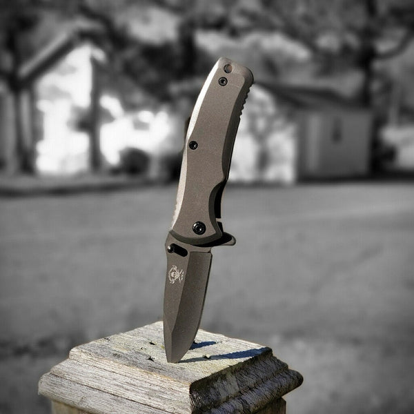 Folding knife on a wooden post with a blurred outdoor background