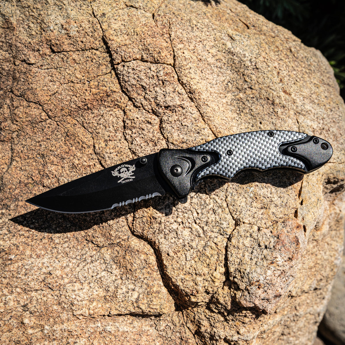 Folding knife with carbon fiber handle on a rock