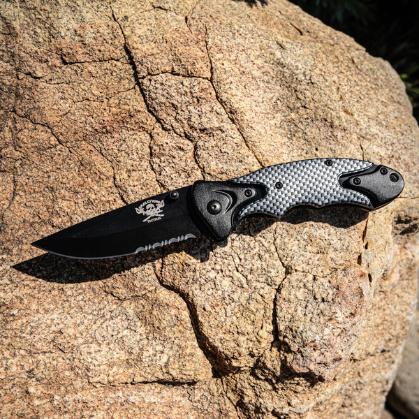 Folding knife with carbon fiber handle on a rock
