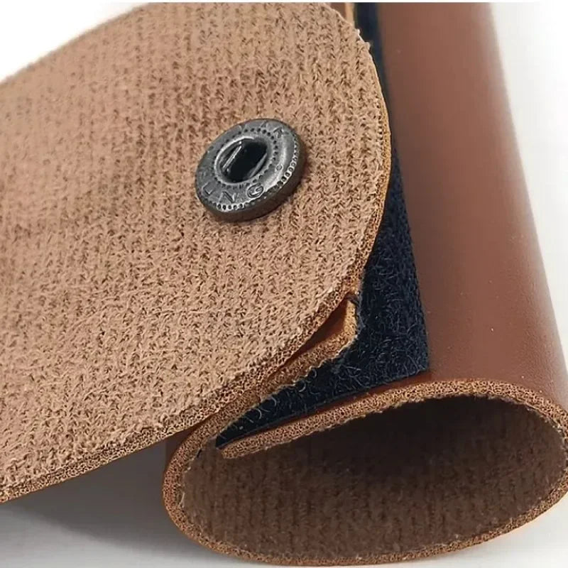 Close-up of a brown leather product with a button on a white background