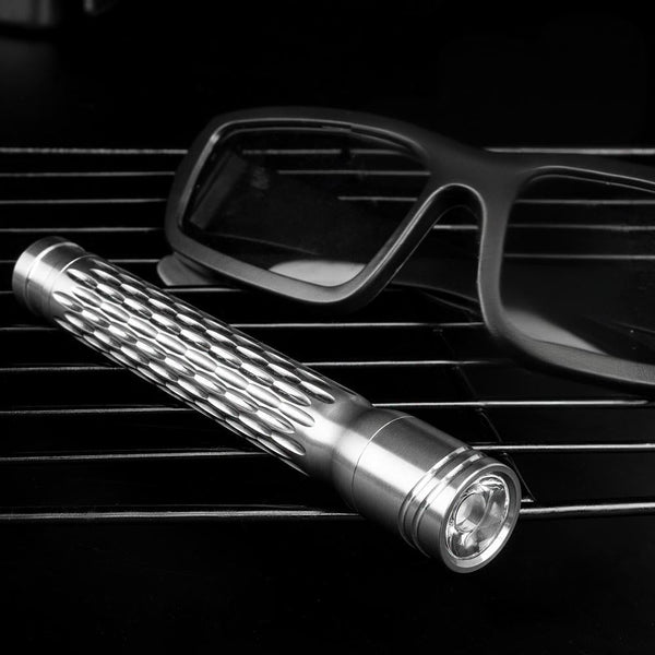 Flashlight on car dashboard with sunglasses in the background